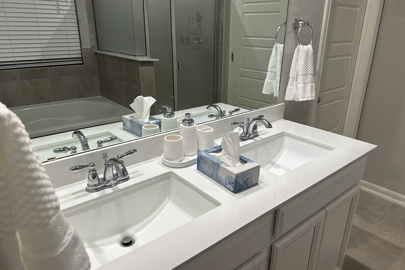 Master bath with double sinks and a private toilet room.