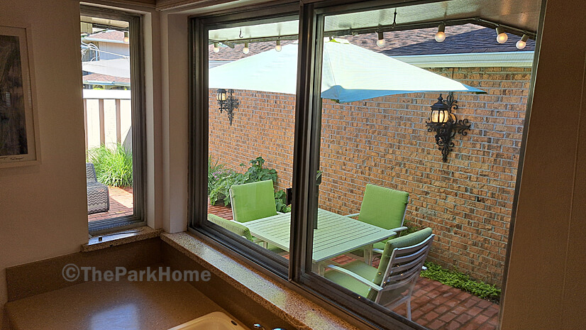 Windows above kitchen sink look onto patio.