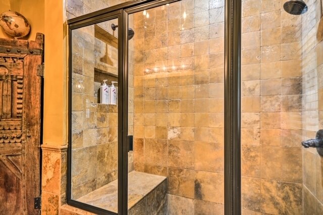 Wonderfully large shower with 2 heads and a stone seat