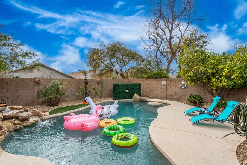 Swimming pool with fountain, inflatable toys, lounge chairs