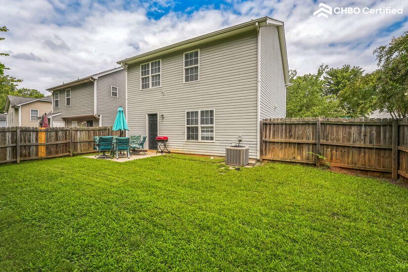 Fenced yard with BBQ grill.
