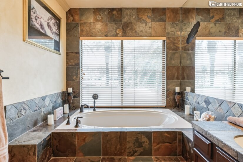 Large soaking tub with mountain and palm tree views