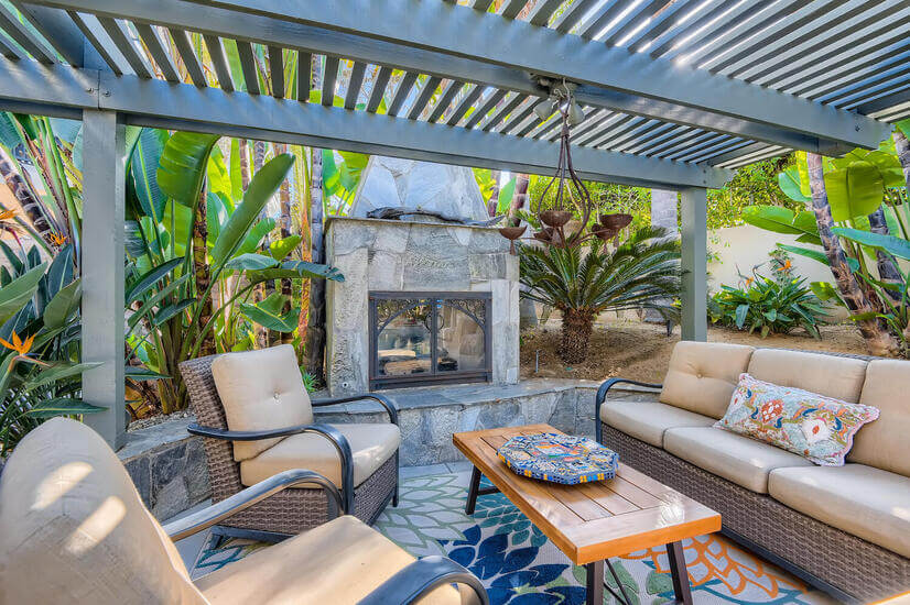 Outdoor fireplace and seating area under Pergola