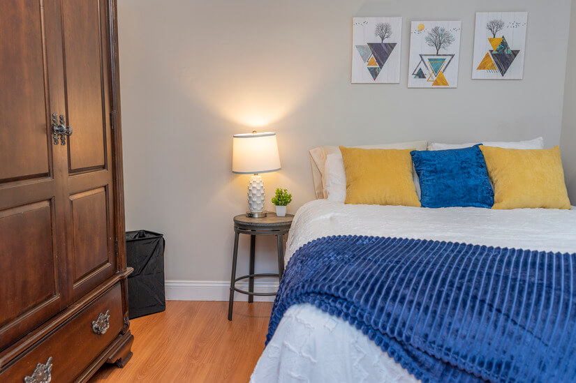 Bedroom 1 features a queen bed and storage armoire.