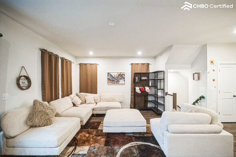 Living area facing bookshelf and stairs