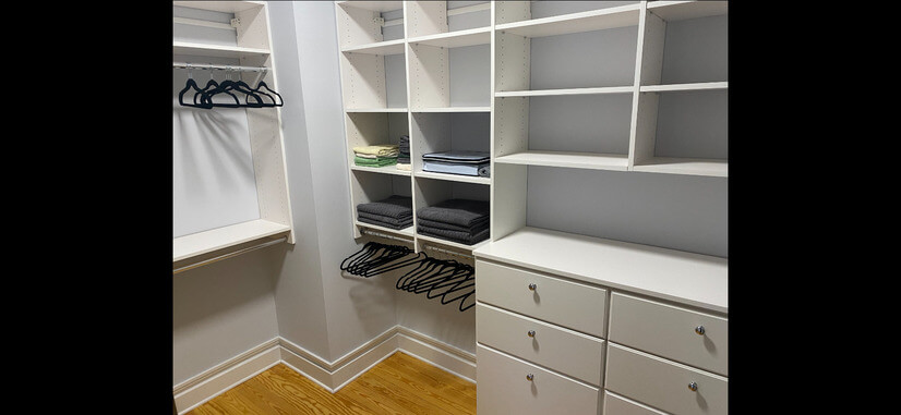 Walk-in closet with 3 sides of shelves and clothing racks