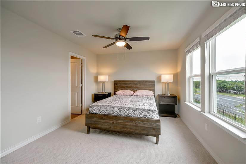 Master bedroom with queen bed and ceiling fan.