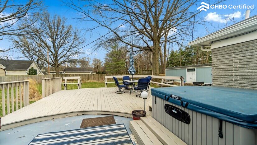 Large wood deck leading to large fenced-in back yard