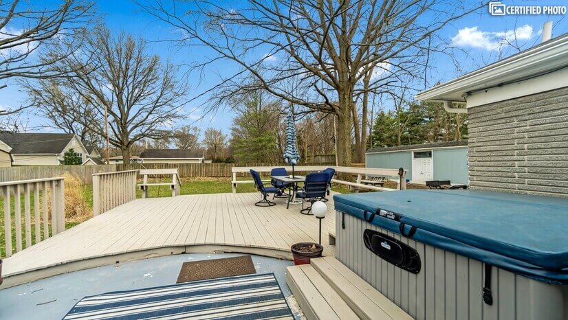 Large wood deck leading to large fenced-in back yard
