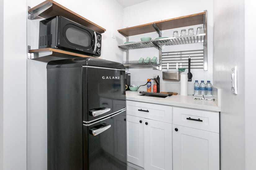 Kitchenette with fridge, microwave and dishes