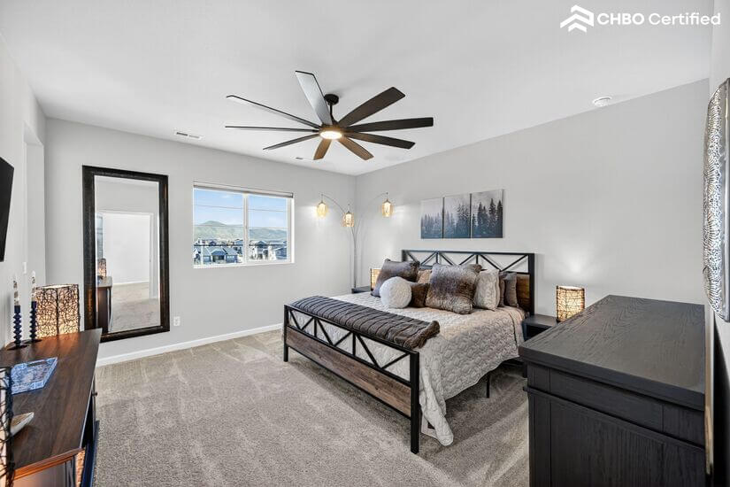 King bed, dresser,furnishings & ceiling fan in owner's suite