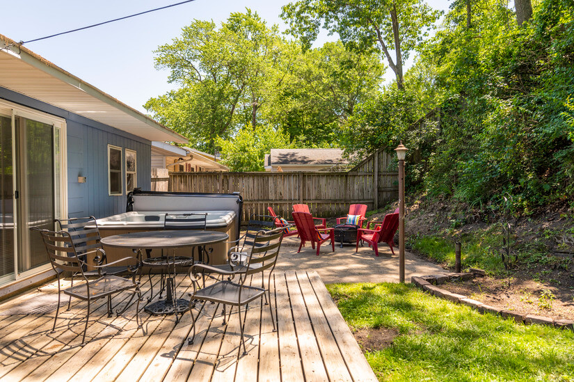 Backyard has it all: Outdoor dining spot, hot tub, + firepit