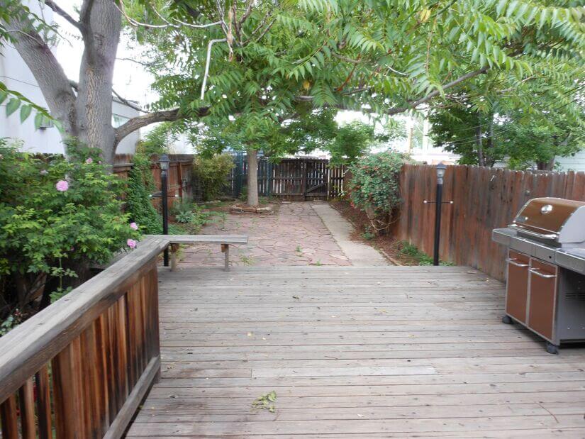 fenced in yard with deck/patio and gas grill