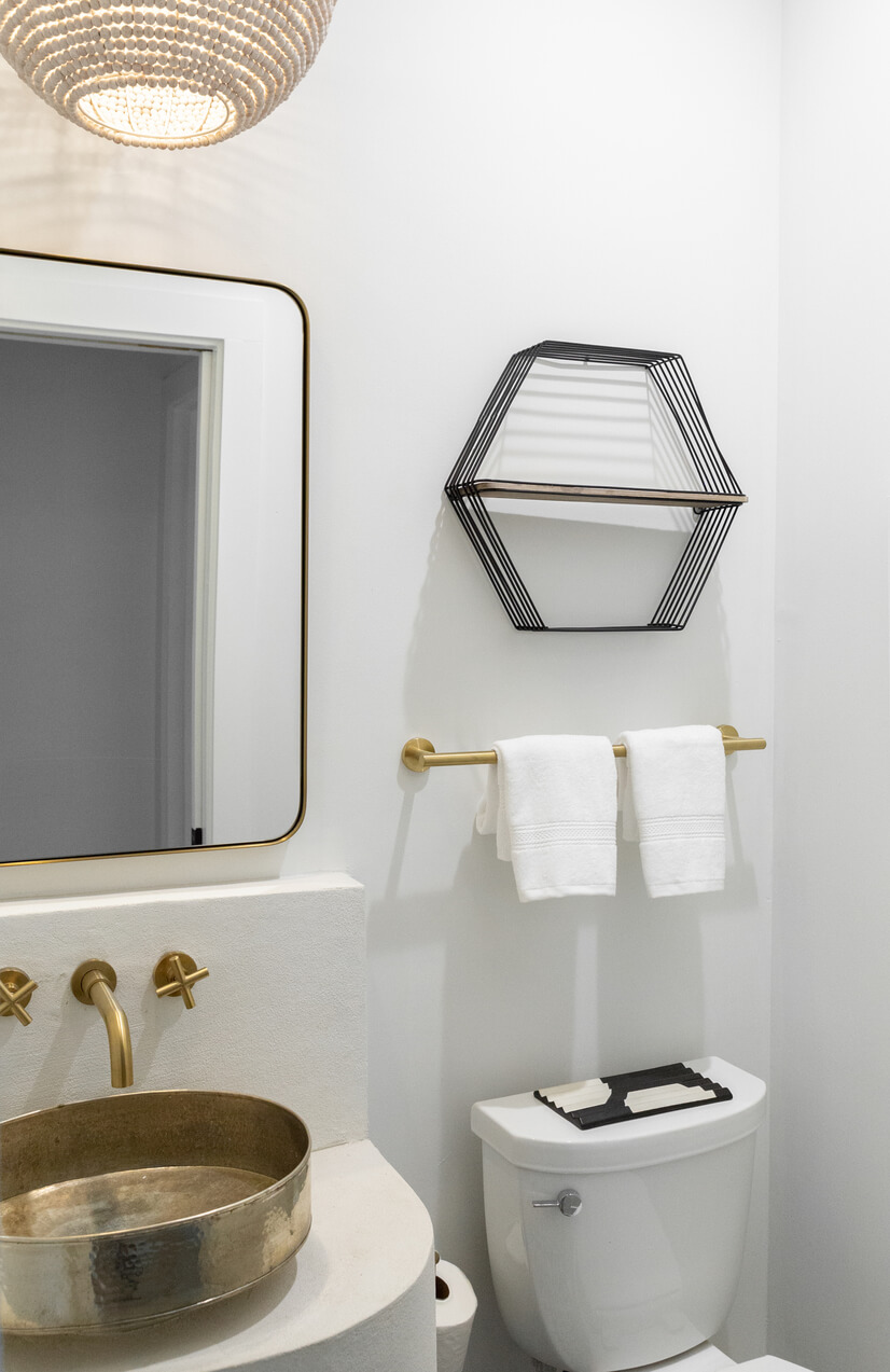 Gold-accented powder room with wall mirror
