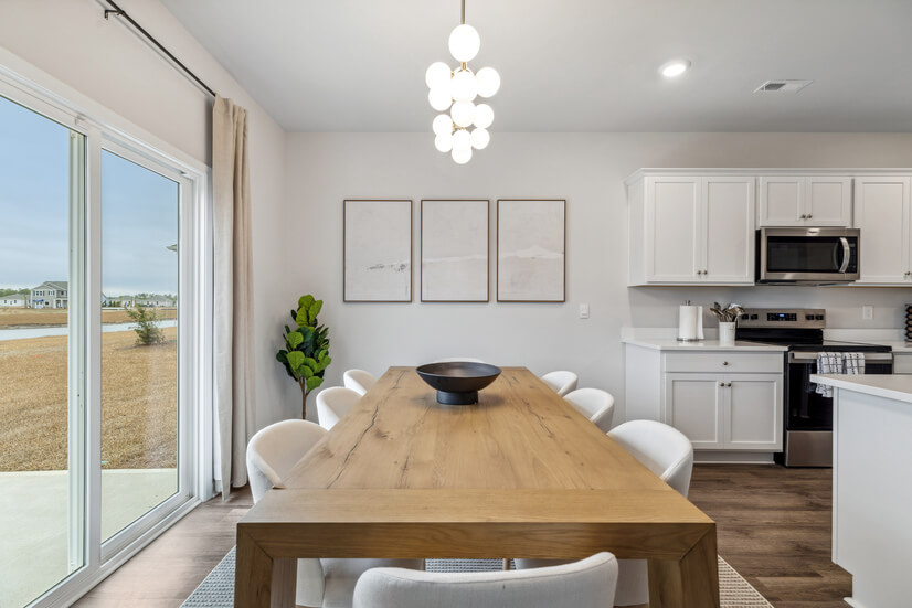 Gather around a sleek Capra table under a modern chandelier