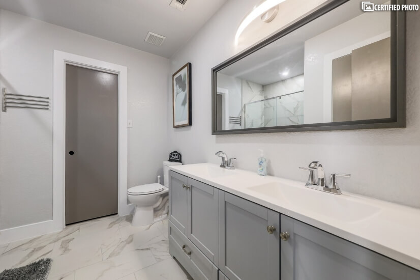 Primary en-suite bathroom with double vanities.