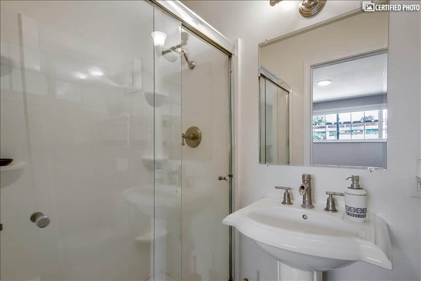 Well-lit bathroom with walk-in shower
