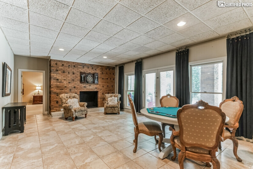 Basement walkout area with poker table and fireplace.
