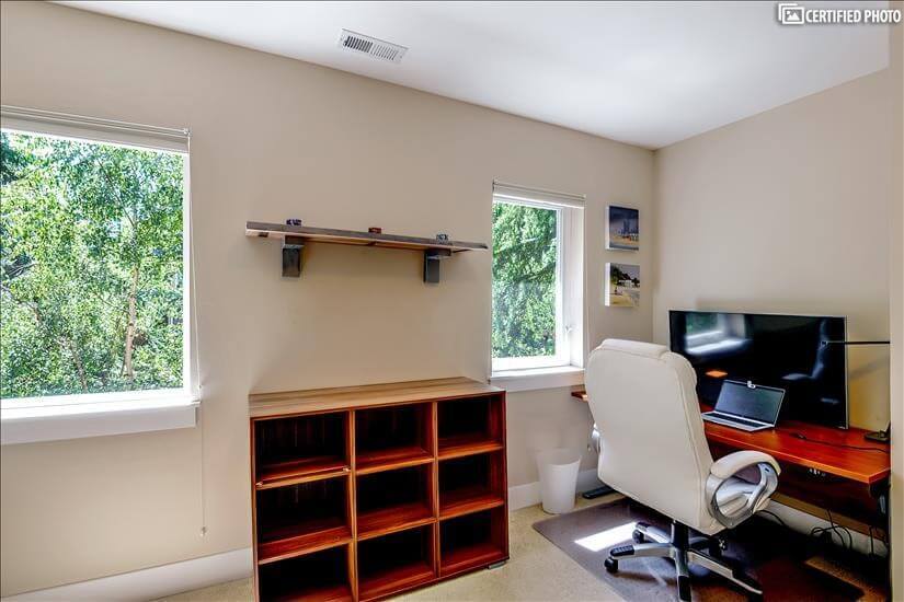 Twin bedroom doubles as office with large monitor