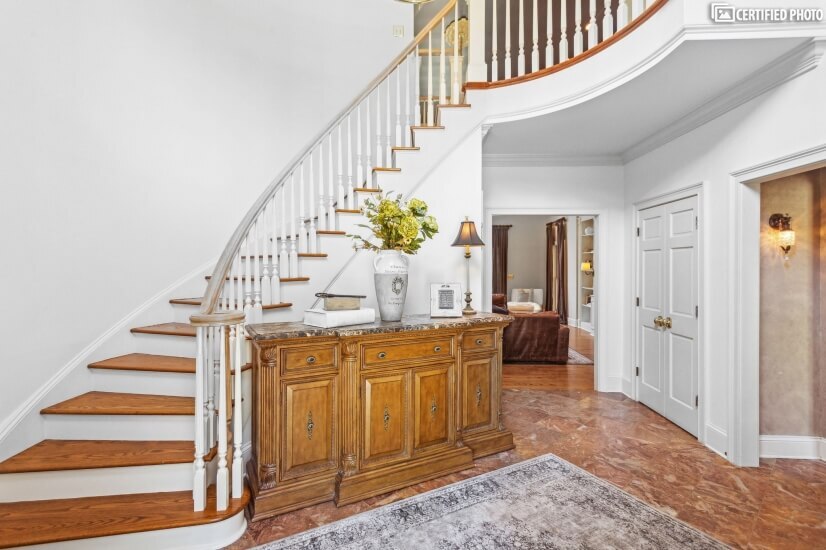 Grand entrance stairs to second floor in two story entryway.