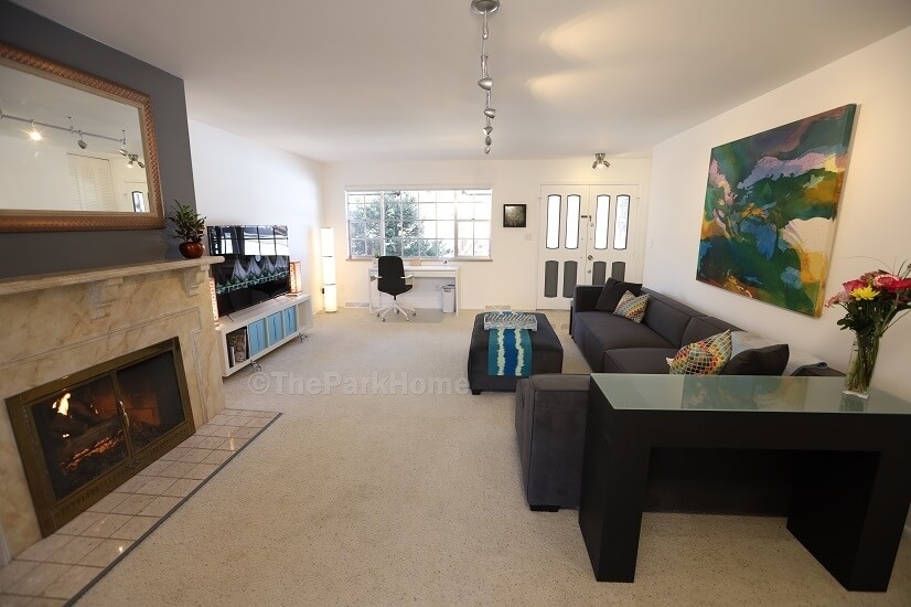 Comfortable furnishings, gas fireplace, 65” TV, workspace.