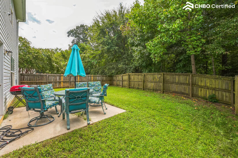 Large fenced yard with patio set.