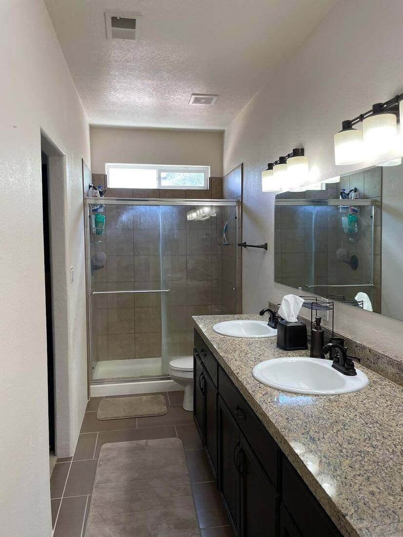 Master bathroom with walk-in shower and twin vanities.