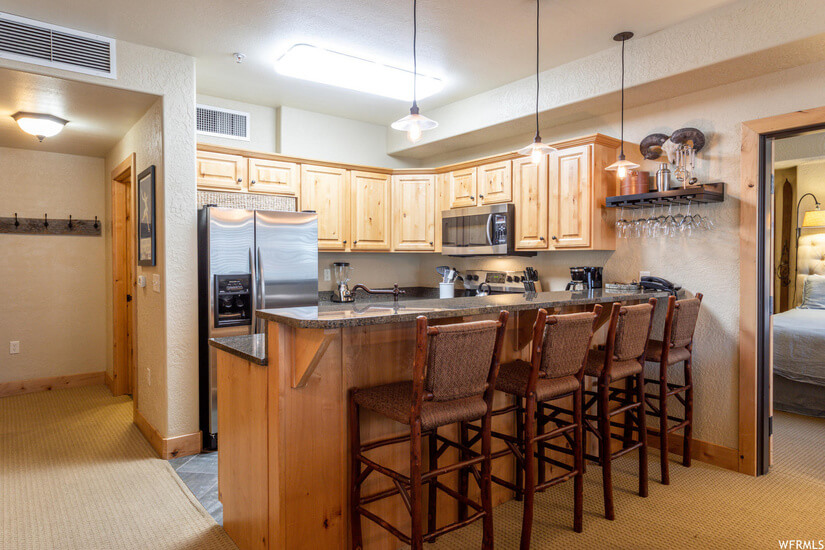 Nice kitchen with bar stools, stainless steel appliances