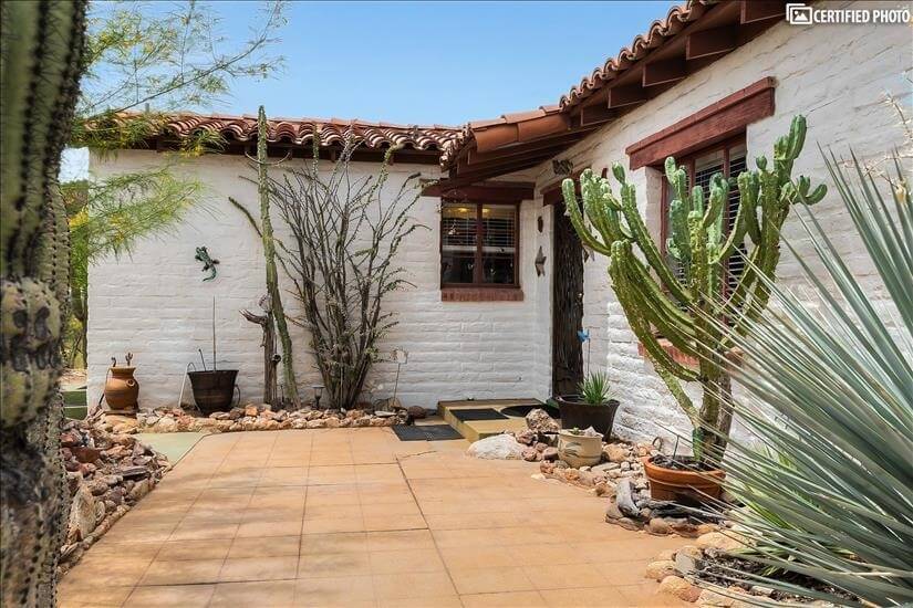 Front porch protected by saguaros & other des