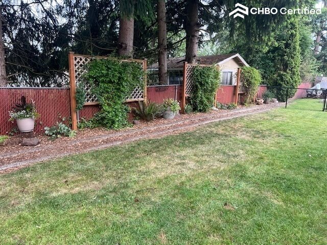 Spacious partially fenced backyard.