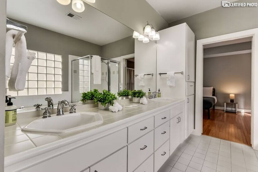 Same bathroom showing wash basin and cabinets