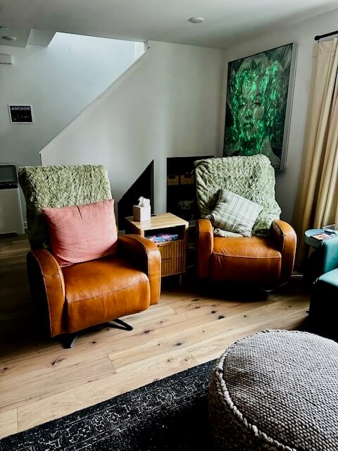 Two recliners and a giant wall-mounted TV in the sun-lit LR