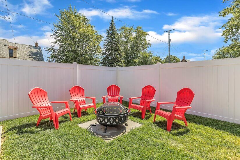 Comfy Adirondack chairs surround the firepit.