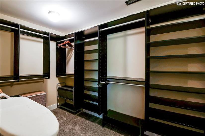 Primary bedroom walk-in closet with ironing board