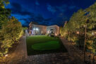 Well lit up backyard with landscape lighting