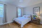 Spacious, bright queen bedroom with blackout