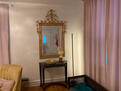 Grand mirror over marble table greets you.