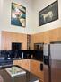 well lit kitchen w island and artwork
