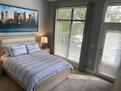 Carpeted master bedroom w balcony