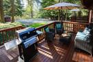 Spacious deck with grill, seating, umbrella.