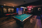 Spacious game room with a pool table.