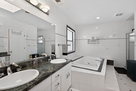 The primary bathroom features a large tub and