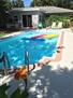 Pool with rafts, chaise lounges, and chairs
