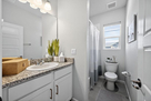 Upstairs guest bath with vanity, tub, and sho