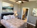 Beautiful artwork and ceiling fan in bedroom