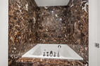 Jetted bathtub with veined marble surround