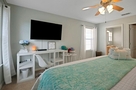 Primary bedroom with large TV and desk/chair