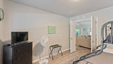 Third bedroom opens to living area. Small TV.