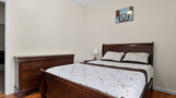 Bedroom with full-size bed, dresser, and clea