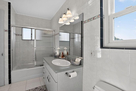 The upper level guest bathroom features a sho